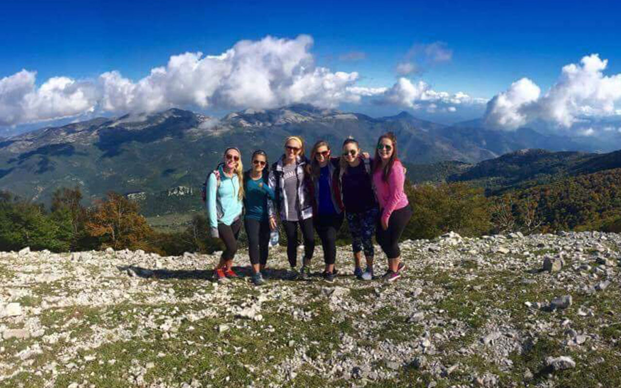 Assumption students pose before mountains on the outskirts of Rome.