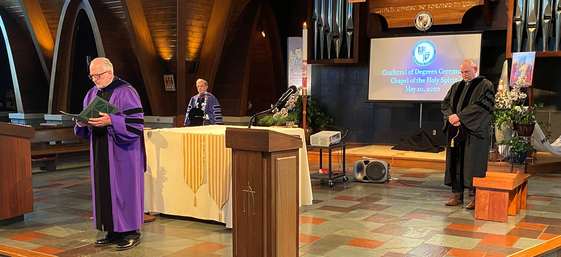 Father Richard Lamoureux, A.A., Ph.D., Vice President for Mission delivers the benediction at the Conferral of Degrees ceremony held in the Chapel of the Holy Spirit. Behind Fr. Lamoureux is College President Francesco C. Cesareo, Ph.D., and Provost Greg Weiner, Ph.D.
