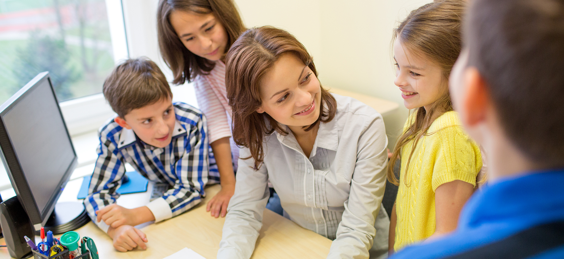 Photo of a teacher with students used to promote Assumption University's School Counseling program.