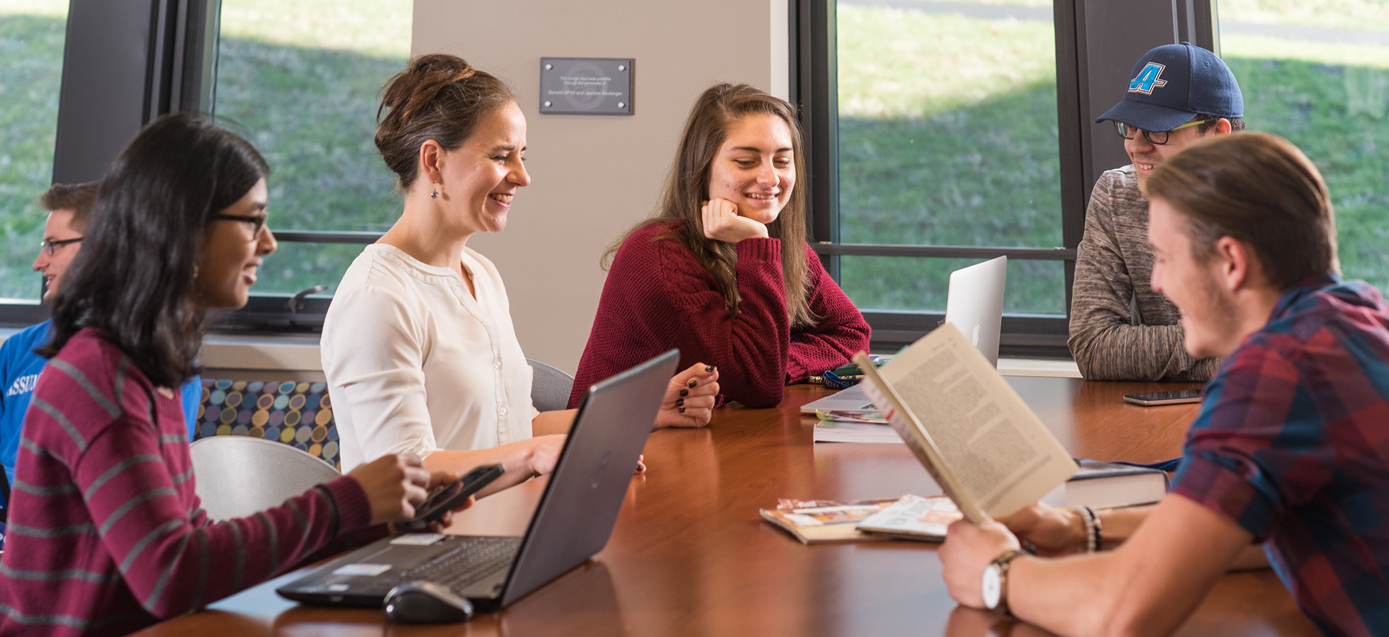Assumption University faculty and students gathered around a table in the Tsotsis Family Academic Center.