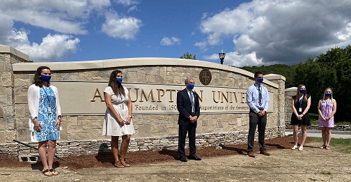 Assumption University President Francesco Cesareo poses in front of the new University sign with students