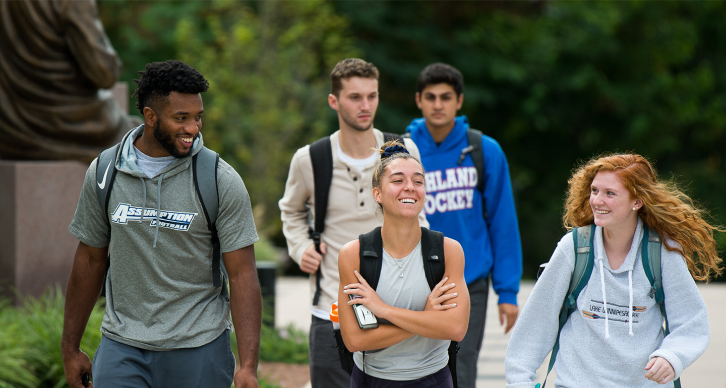 Assumption students enjoying a walk through campus on a spring day.