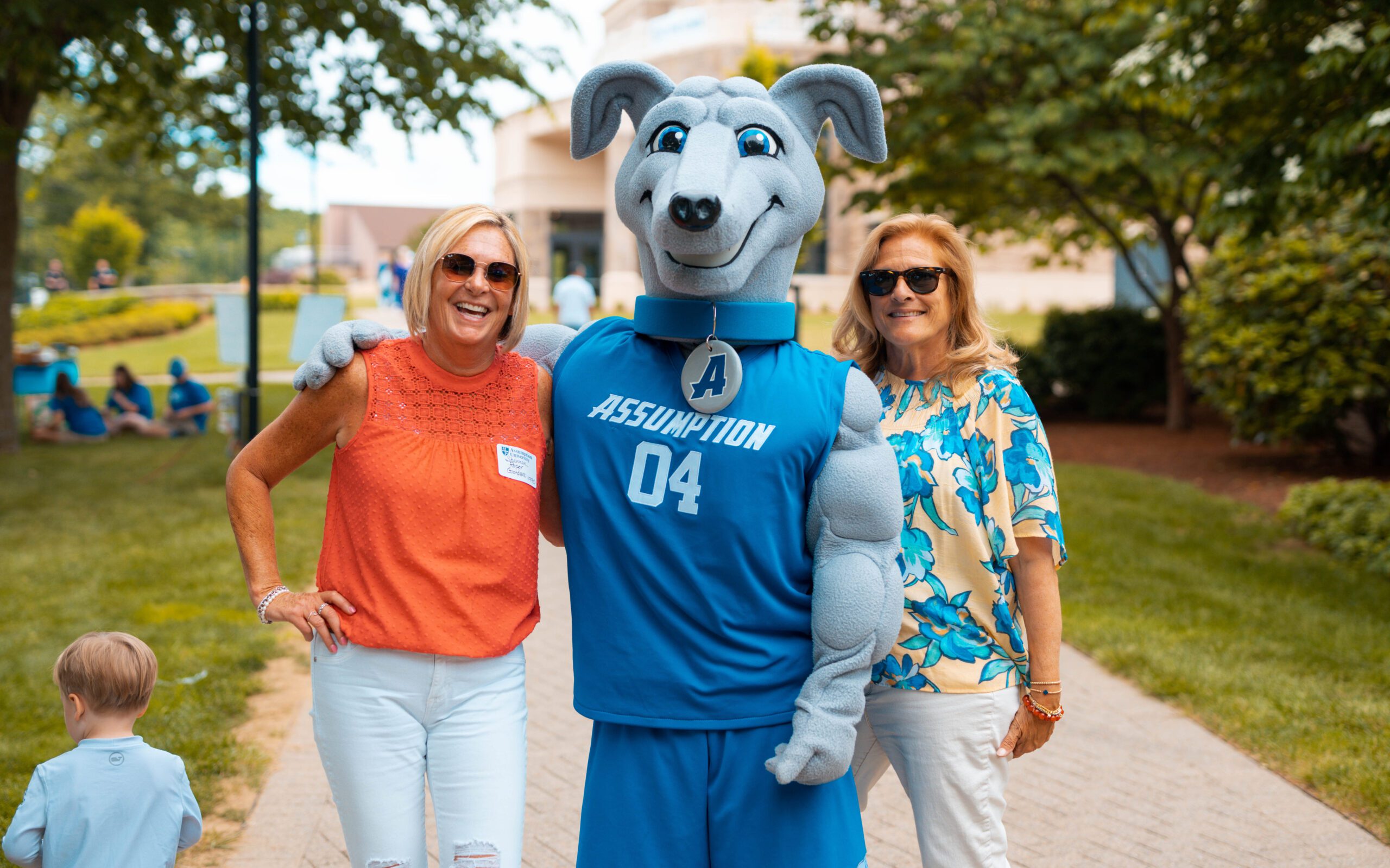 Two female Assumption alumni taking a photo with Piere.