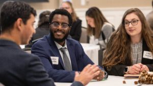 Students attending a career event and talking at a table.