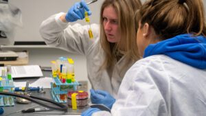 Two students working in a lab looking at a test tube.