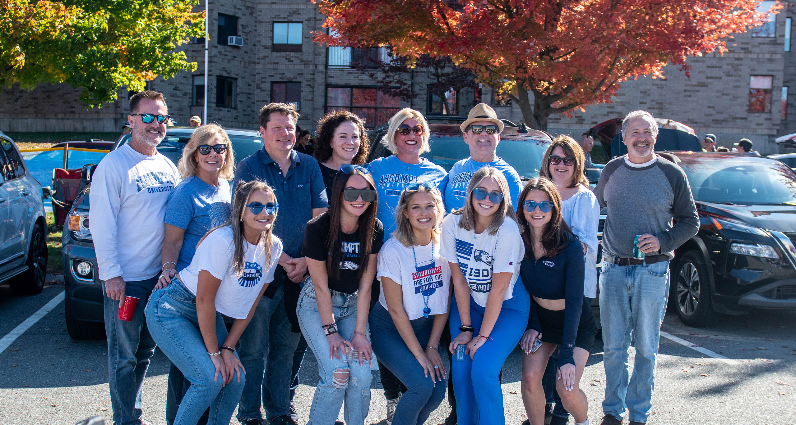 group of Assumption alumni and students wearing blue Assumption gear