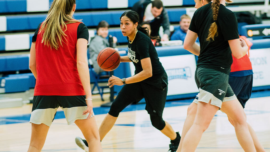 Assumption student dribbles a basketball during a game