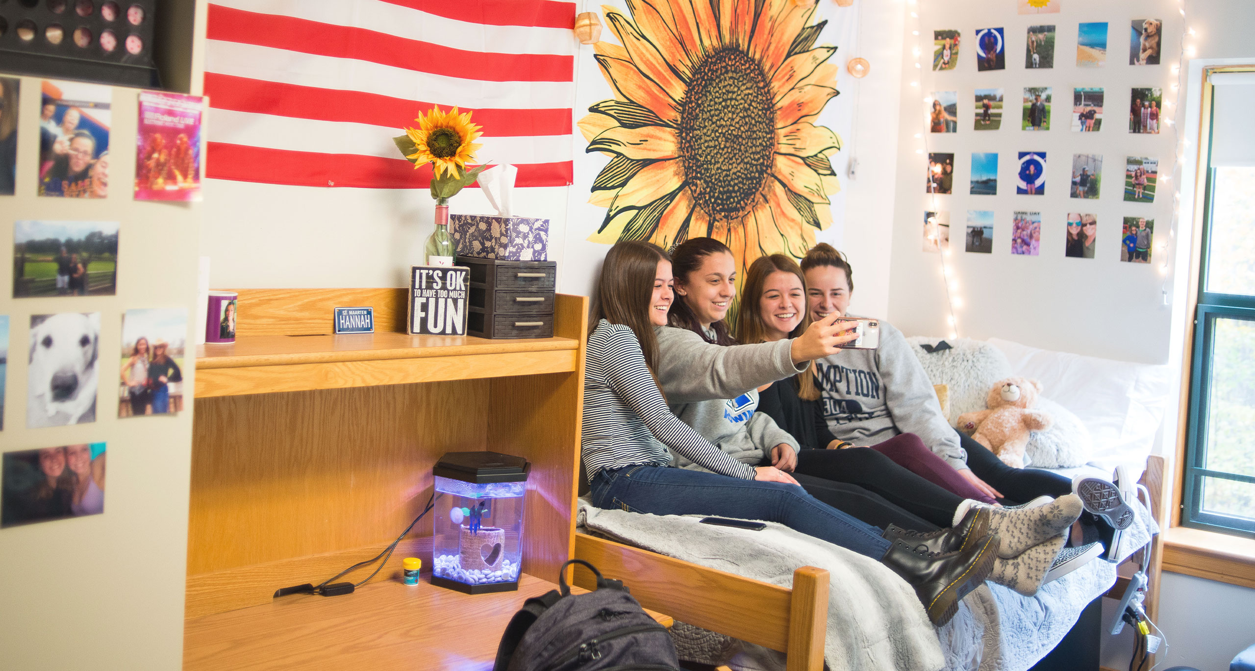 Assumption students sitting on a bed taking a selfie