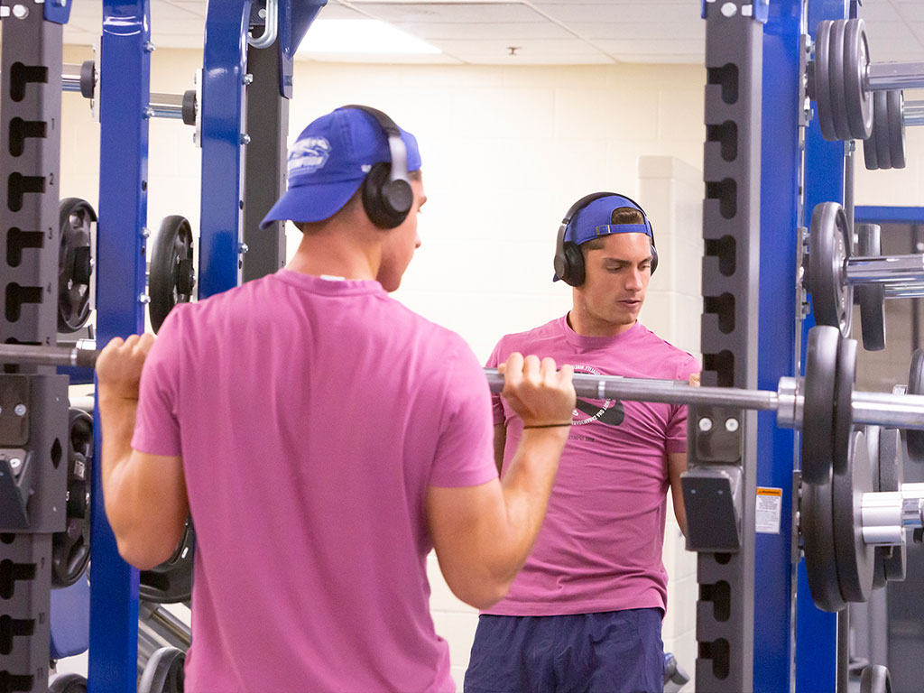 Assumption student during a workout in the Plourde Recreation Center's recreational weight room.