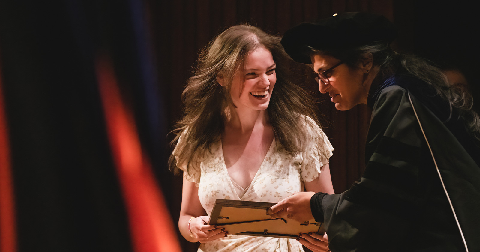 A student is excited when accepting an award from a professor.