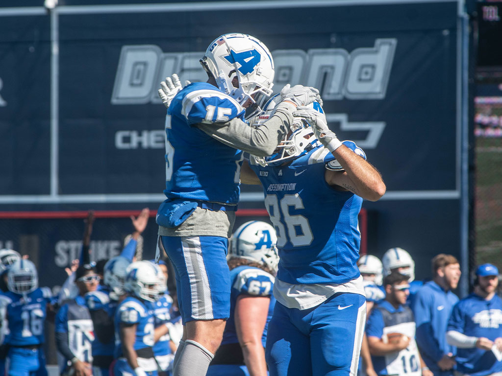 Assumption Greyhound football players celebrate during a game