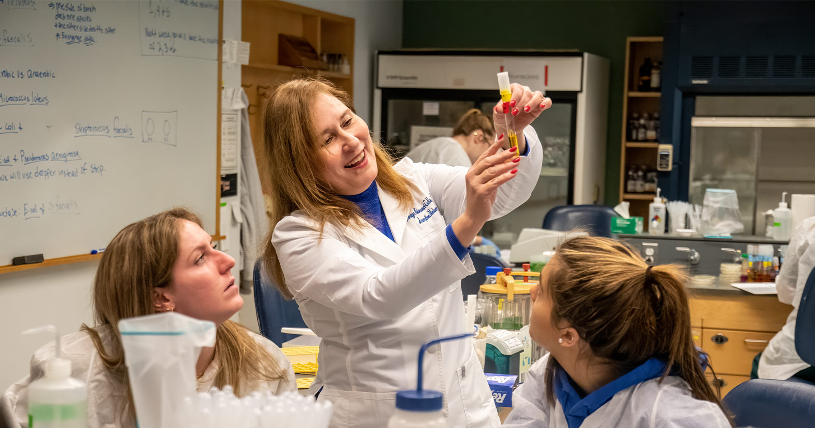 A faculty member at Assumption University demonstrates material in a lab to students.