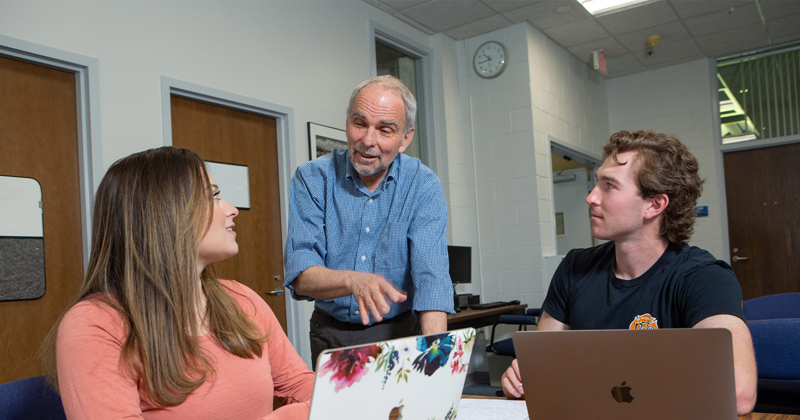 A faculty member from Assumption University supports students during a course.