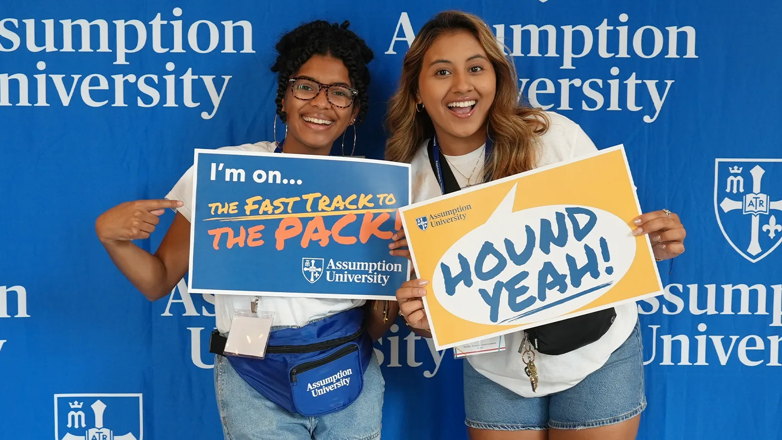 Two Assumption students holding up a sign that says "Hound yeah"