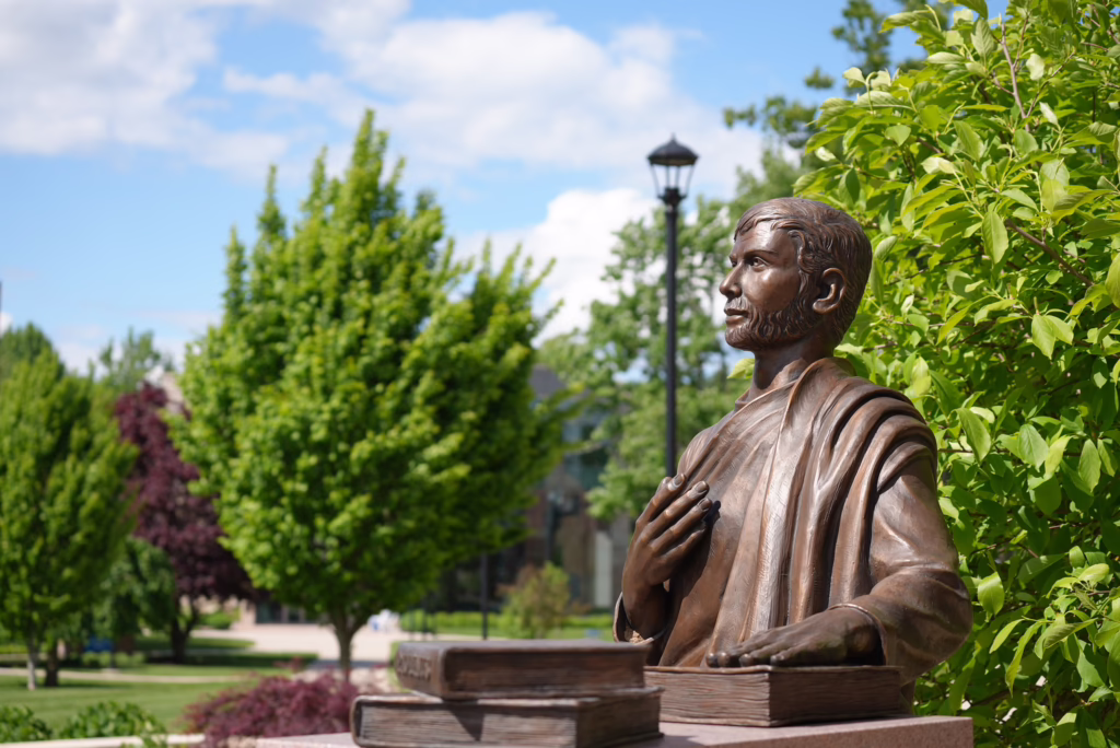 Statue of St. Augustine in front of the Tsotsis Family Academic Center at Assumption University